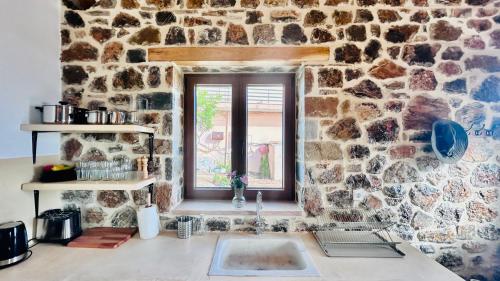 een stenen keuken met een wastafel en een raam bij Cassiopea Guest House Evia Greece in Nerotriviá