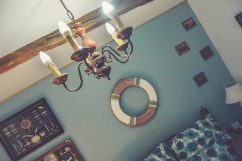 a chandelier in a room with a bed and a mirror at Édes Otthon Vendégház in Nagybörzsöny