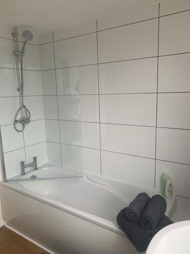 a white bath tub with two towels sitting in it at Silk Mill Apartment in Macclesfield