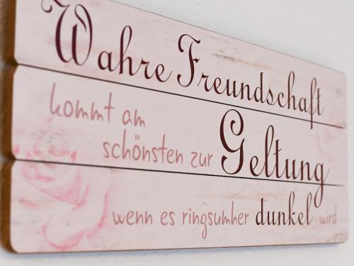 ein Satz von drei Holzschildern mit rosa Rosen in der Unterkunft Ferienwohnung Gaby Lehmann in Hornberg