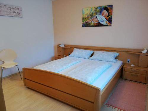 1 cama en un dormitorio con una foto en la pared en Ferienwohnung Gaby Lehmann, en Hornberg