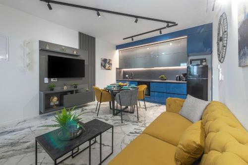 a living room with a yellow couch and a kitchen at Sunset Premium Residence II & III in Dubrovnik