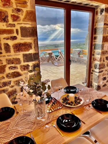 a table with plates of food and a view of the ocean at Cassiopea Guest House Evia Greece in Nerotriviá