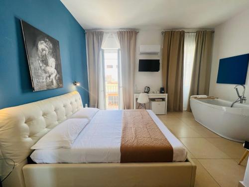 una camera con un grande letto e una vasca da bagno di Les Chambres de Françoise Guest House a Olbia