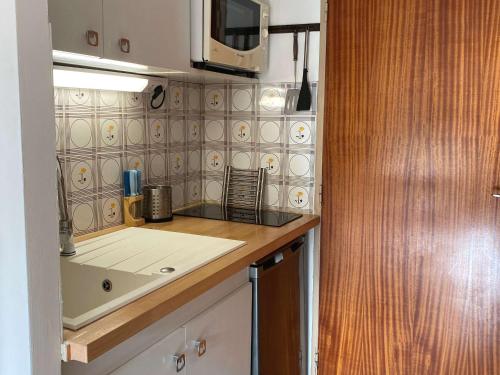 a kitchen with a sink and a microwave at Studio Balaruc-les-Bains, 1 pièce, 2 personnes - FR-1-553-134 in Balaruc-les-Bains