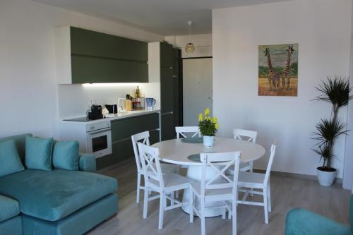 a living room with a table and chairs and a kitchen at Savana Modern Apartment by the sea in Golem