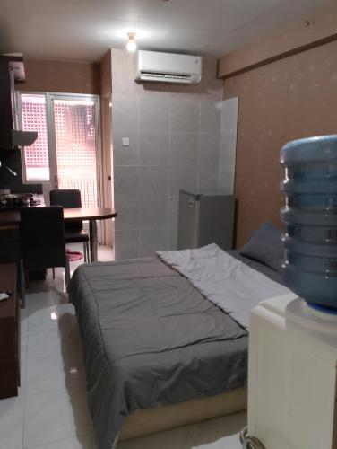 1 dormitorio con cama, escritorio y mesa con mesa en Apartemen Kalibata City by MatajiFamily en Yakarta