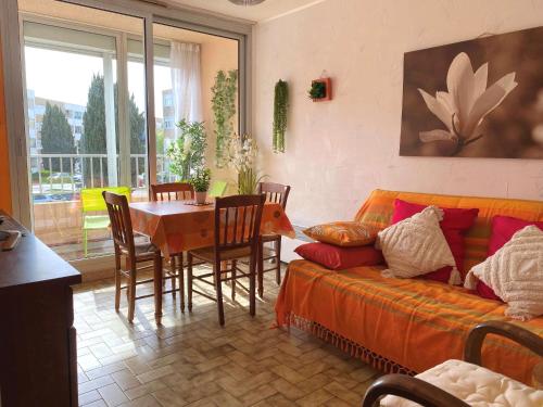 un salon avec un canapé, une table et des chaises dans l'établissement Appartement T2 avec loggia, proche centre et étang de Thau - calme, équipé, 34540 Balaruc-les-Bains - FR-1-553-251, à Balaruc-les-Bains