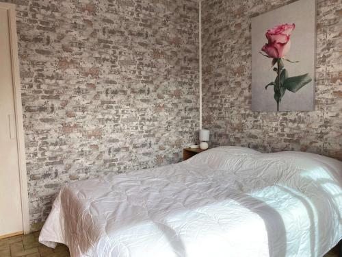ein Schlafzimmer mit einem weißen Bett und einer Ziegelwand in der Unterkunft Appartement Balaruc-les-Bains, 1 pièce, 2 personnes - FR-1-553-251 in Balaruc-les-Bains