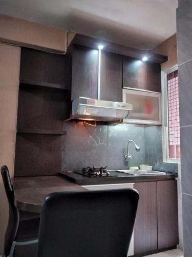 cocina con fregadero y fogones horno superior en Apartemen Kalibata City by MatajiFamily en Yakarta