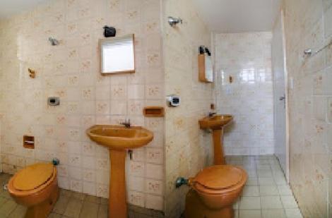 a bathroom with two sinks and two toilets at Hotel La Rocca, Goiânia in Goiânia