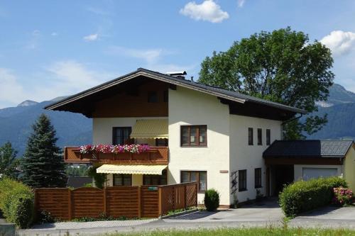 een huis met een balkon en bergen op de achtergrond bij Gemütliches Appartement in Abtenau mit Garten und Terrasse in Abtenau