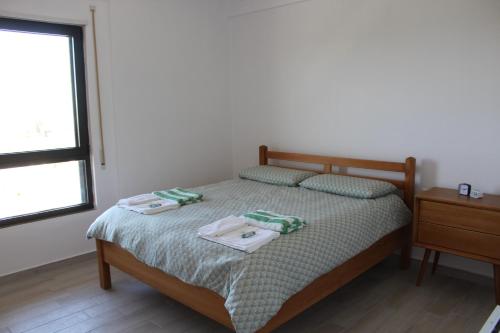 a bedroom with a bed with two towels on it at Savana Modern Apartment by the sea in Golem