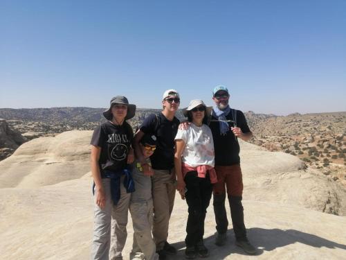 un grupo de personas de pie en una roca en el desierto en Dana local life Eco Lodge, en Dana