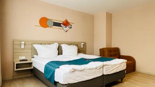 a hotel room with a bed and a chair at Hotel Libers in Lauterbach