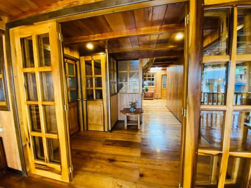 a hallway of a house with wooden floors and glass doors at Guayabo Hostal Spa in Mindo