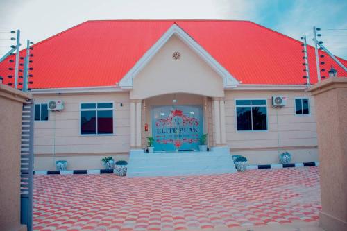 un edificio con techo rojo y entrada de baldosas rojas en ELITE PEAK LUXURY LODGE, en Dodoma