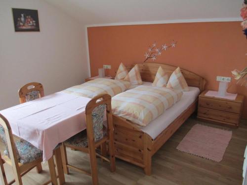 a bedroom with a large wooden bed with two chairs at Apartment für zwei Erwachsene und ein Kind mit Balkon - b57048 in Bad Füssing