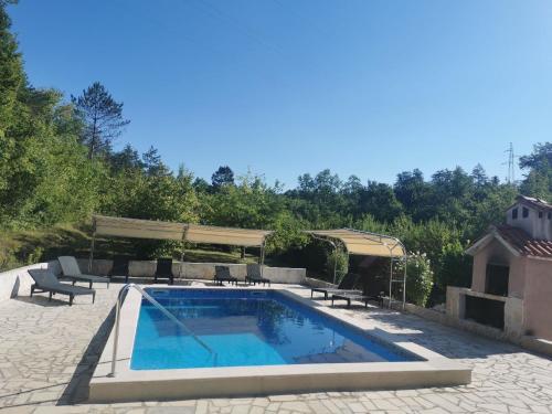 - une piscine sur une terrasse avec des chaises et une table dans l'établissement Ferienhaus in Mala Huba mit Privatem Pool, à Buzet