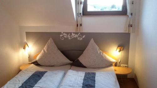 a bedroom with a bed with pillows and a window at Wohnung mit Blick auf die Weinberge in Kröv