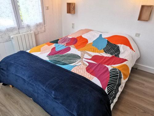 Bett mit farbenfroher Decke in einem Zimmer in der Unterkunft Entre mer et foret 2 in Jard-sur-Mer
