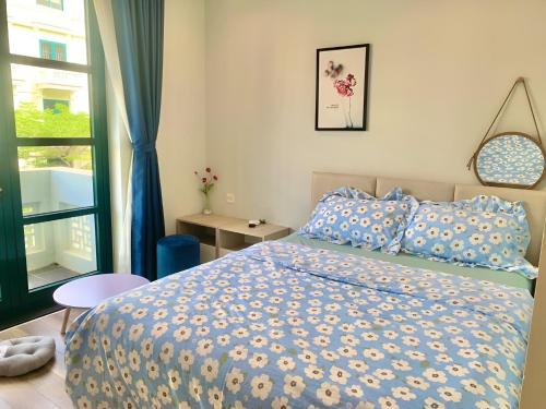 a bedroom with a bed with a blue and yellow comforter at Minh Anh Hotel in Phu Quoc
