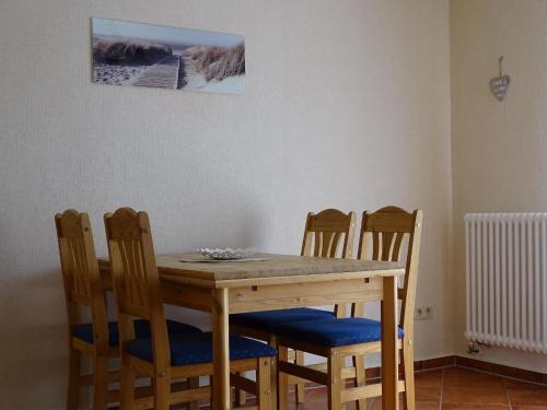 einen Esstisch mit 4 Stühlen, einem Tisch und einem Bild in der Unterkunft Moderne Ferienwohnung in Pudagla mit Grill, Garten und Terrasse in Pudagla