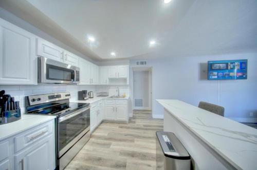 a kitchen with white cabinets and a stove top oven at Mahalo Isles Apartments by Rocketstay in Fort Lauderdale
