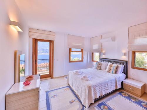 a bedroom with a large bed and a balcony at Villa Sarpedon in Kaş