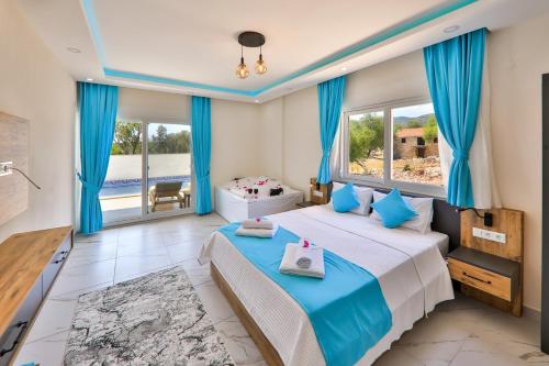 a bedroom with a large bed with blue curtains at Rhapsody Hotel Kas in Kaş
