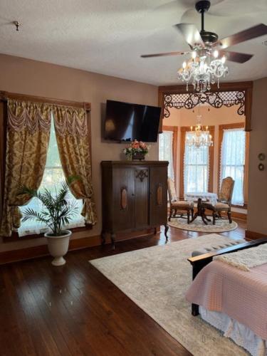 a living room with a bed and a flat screen tv at Woodbine Inn and Restaurant in Madisonville