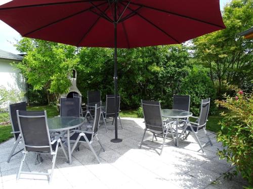 a table and chairs with a red umbrella at Ferienwohnung 2 in Pudagla auf der Insel Usedom in Pudagla