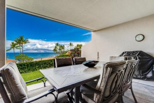 a dining room with a table and a view of the ocean at MAKENA SURF #C102 condo in Wailea