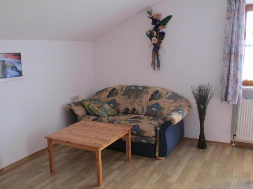 a living room with a couch and a table at Apartment für zwei Erwachsene und ein Kind mit Balkon in Bad Füssing