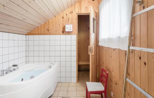 a bathroom with a tub and a red chair at 3 Bedroom Cozy Home In Rdby in Rødby