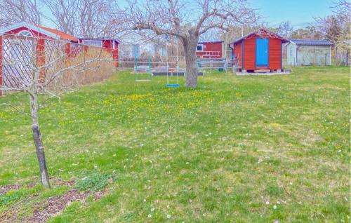 a park with two trees and a playground at Stunning Home In Gotland With Kitchen in Gnisvärd