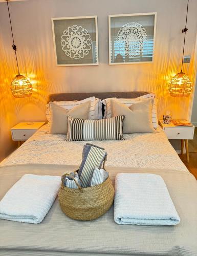 a bed with two towels and a basket on it at Windsor Royal Retreat 2 bed 2 bath & private terrace in Windsor