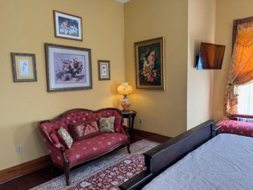 a bedroom with a bed and a couch in it at Woodbine Inn and Restaurant in Madisonville