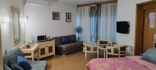 a living room with a couch and a tv and a living room at Palmera El Sokhna Chalets Families Only in Ain Sokhna