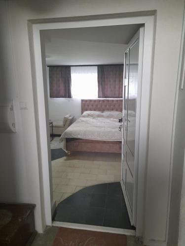 - une chambre avec un lit, une fenêtre et une porte dans l'établissement Apartman Tomic, à Brčko
