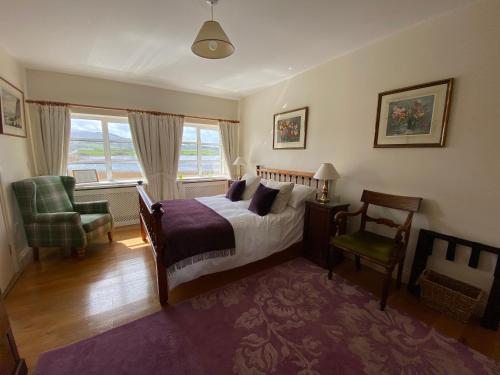 um quarto com uma cama, uma cadeira e uma janela em The Mill em Dunfanaghy