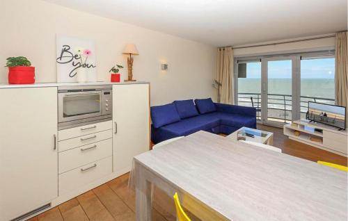 un salon avec un canapé bleu et une cuisine dans l'établissement Residentie Zeezicht, Ref 104, à Ostende
