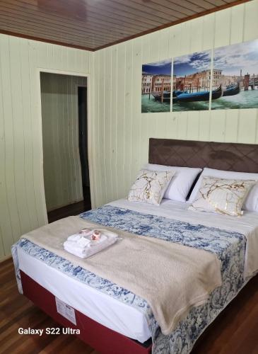 ein Bett in einem Schlafzimmer mit einem Bild an der Wand in der Unterkunft Inteira casa A Cammino di Venezia in Nova Veneza