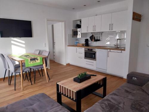 a living room with a table and a kitchen at Homburger 14 in Neunkirchen