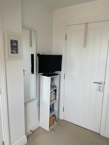 a room with a tv and a white door with a television at Smith's Loft in Chichester