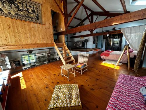 a large living room with wooden floors and a loft at Maison invitant aux voyages 20mn de la plage in Béziers