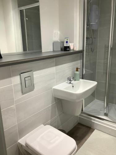 y baño con lavabo, aseo y ducha. en Luxury 1 Bed City Centre Apartment with Free Wifi & Breakfast en Liverpool