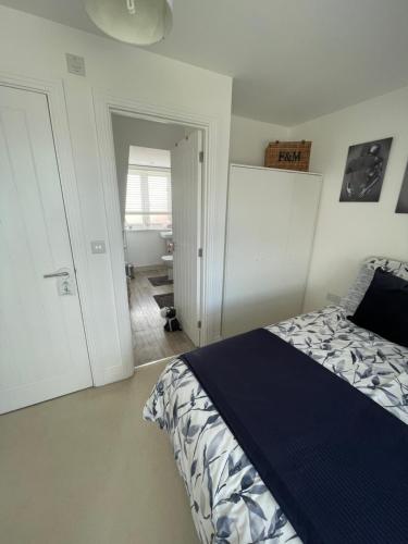 a bedroom with a bed with a blue comforter at Smith's Loft in Chichester