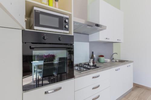 una cocina con microondas y estufa horno superior en Maggie House, en Piacenza