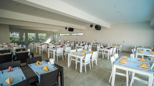 a restaurant with blue tables and white chairs at Catty Cats Garden Hotel in Side